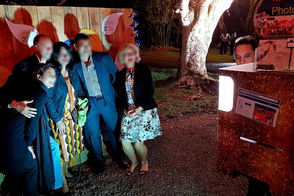 Photobooth at Chateau Labourdonnais with guests posing in group with wooden backdrop